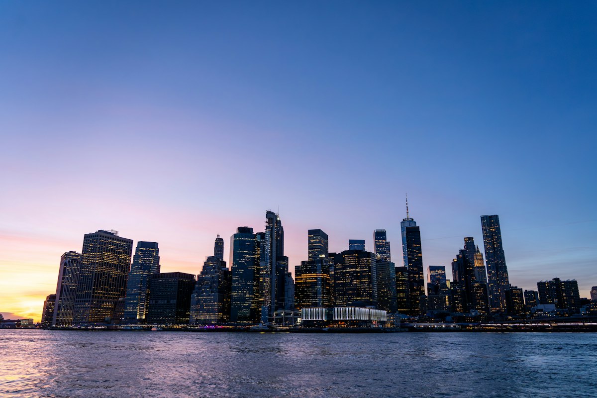Lower Manhattan skyline viewed across the East River at dusk